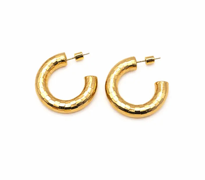 The Allure 30mm Brushed Gold Patterned Hoop Earrings feature a chunky, textured design with a segmented pattern. Tarnish-resistant and bold, they add elegant style to any look. Shown on a white background.