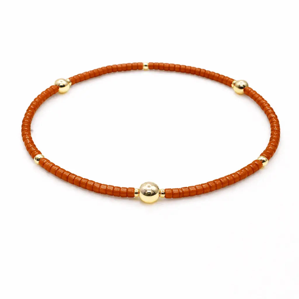 Burnt orange and gold-filled Game Day jewelry bracelet by erin gray featuring intricate design and shiny finish.