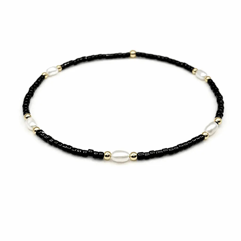 Black and gold-filled waterproof bracelets with pearl accents from erin gray's Game Day jewelry collection.