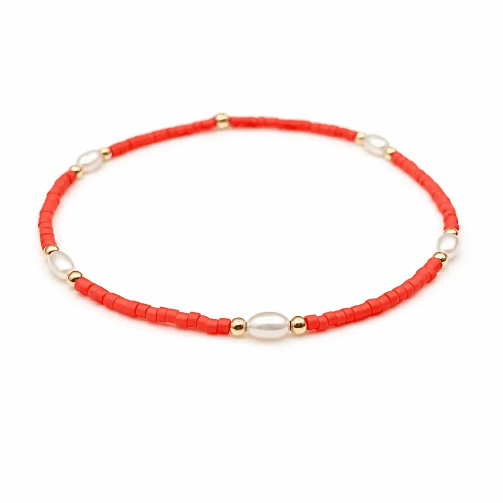 Orange and gold-filled waterproof bracelets with pearl accents from erin gray's Game Day jewelry collection.