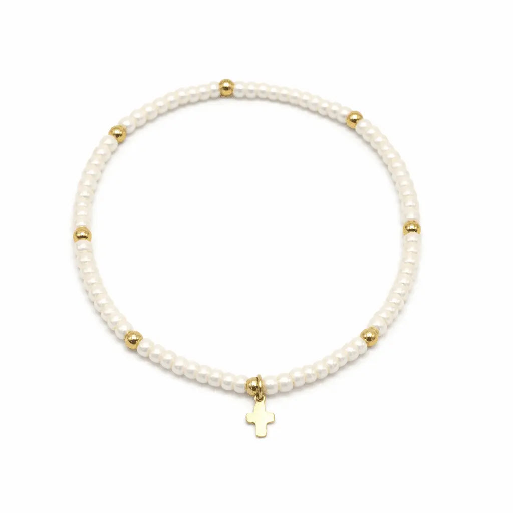 Luxe Cross Bracelet by Erin Gray featuring pearl white beads, gold accents, and a stylish cross charm.