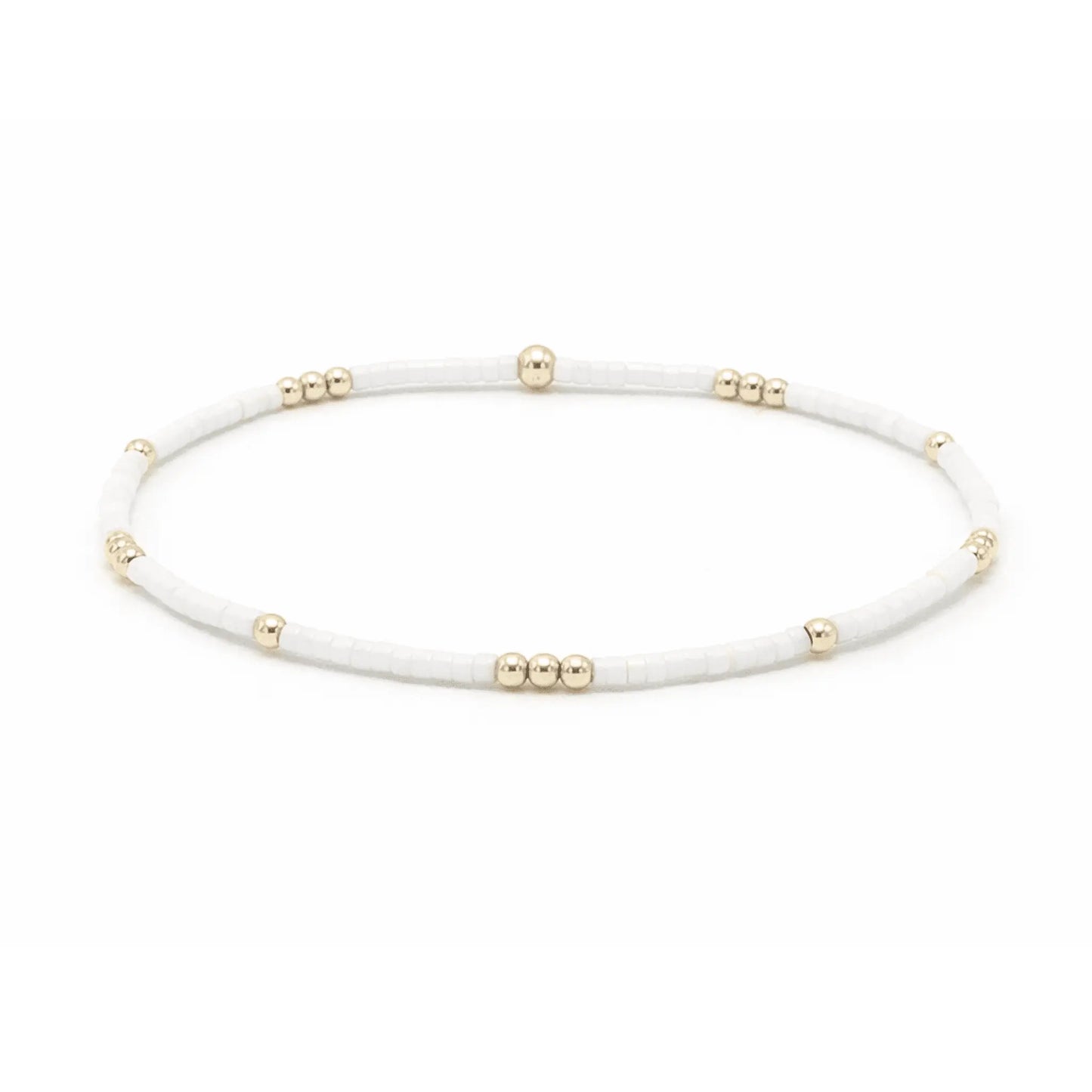 Close-up of erin gray Newport cotton and gold-filled waterproof bracelet with delicate diamond charm on a jewelry display.