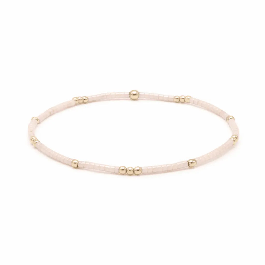 Delicate 2mm Newport pale pink and gold-filled waterproof bracelet by Erin Gray, featuring a thin, elegant jewelry design.