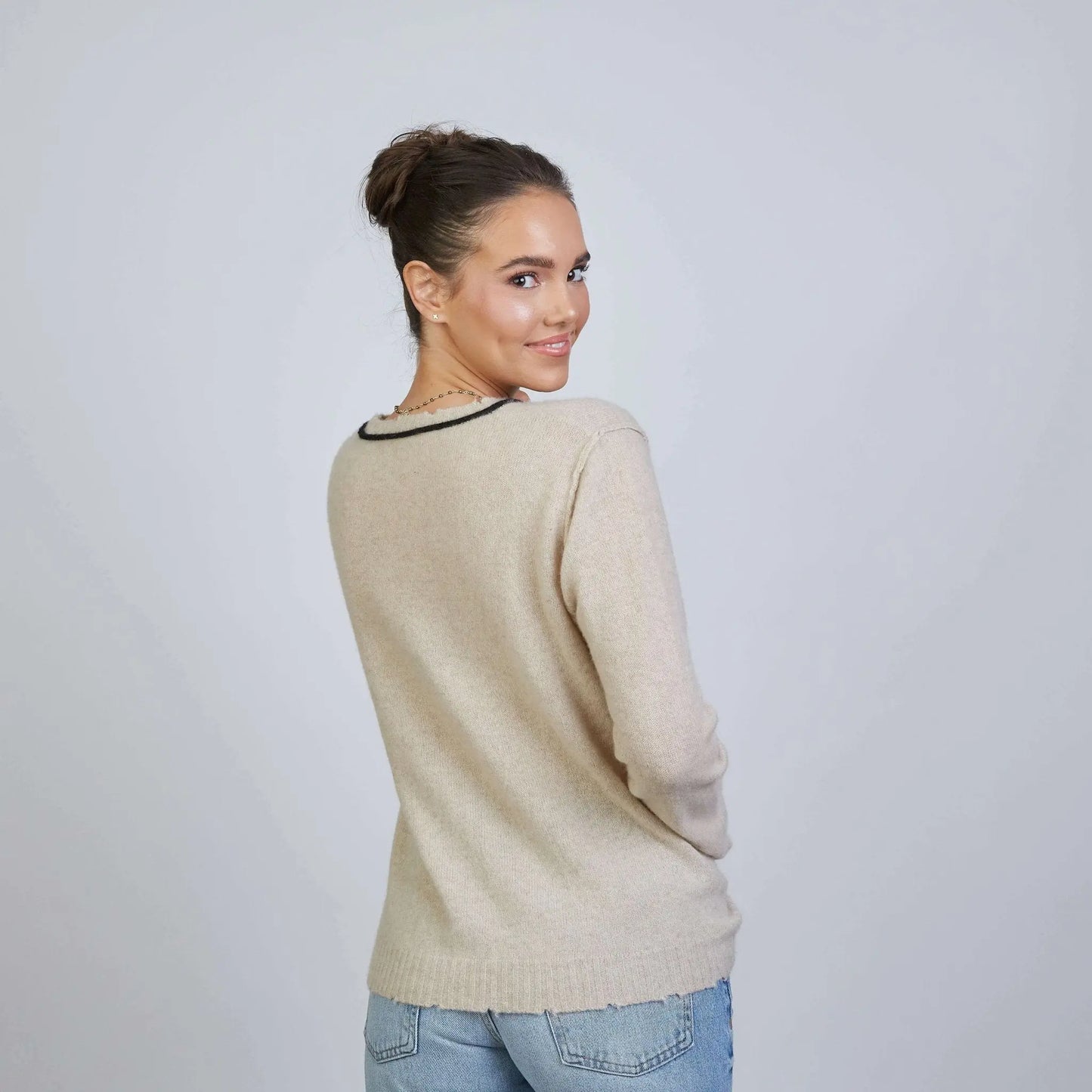 Beige and black Highland Raw Edge Mongolian cashmere sweater by erin gray, showcasing soft fabric and stylish raw edge design.