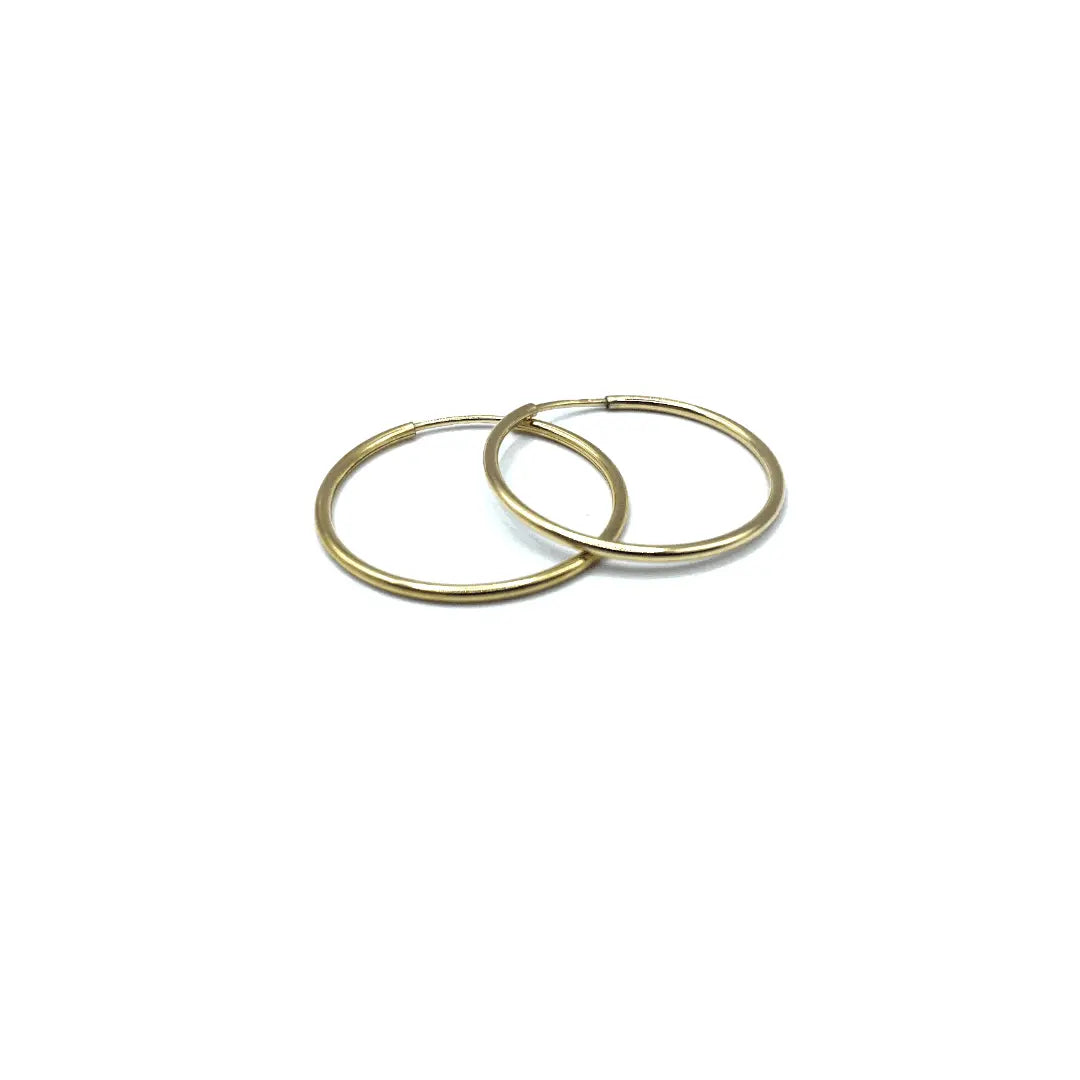 14k gold-filled endless hoop earrings by Erin Gray showcasing a sleek, continuous circular jewelry design.