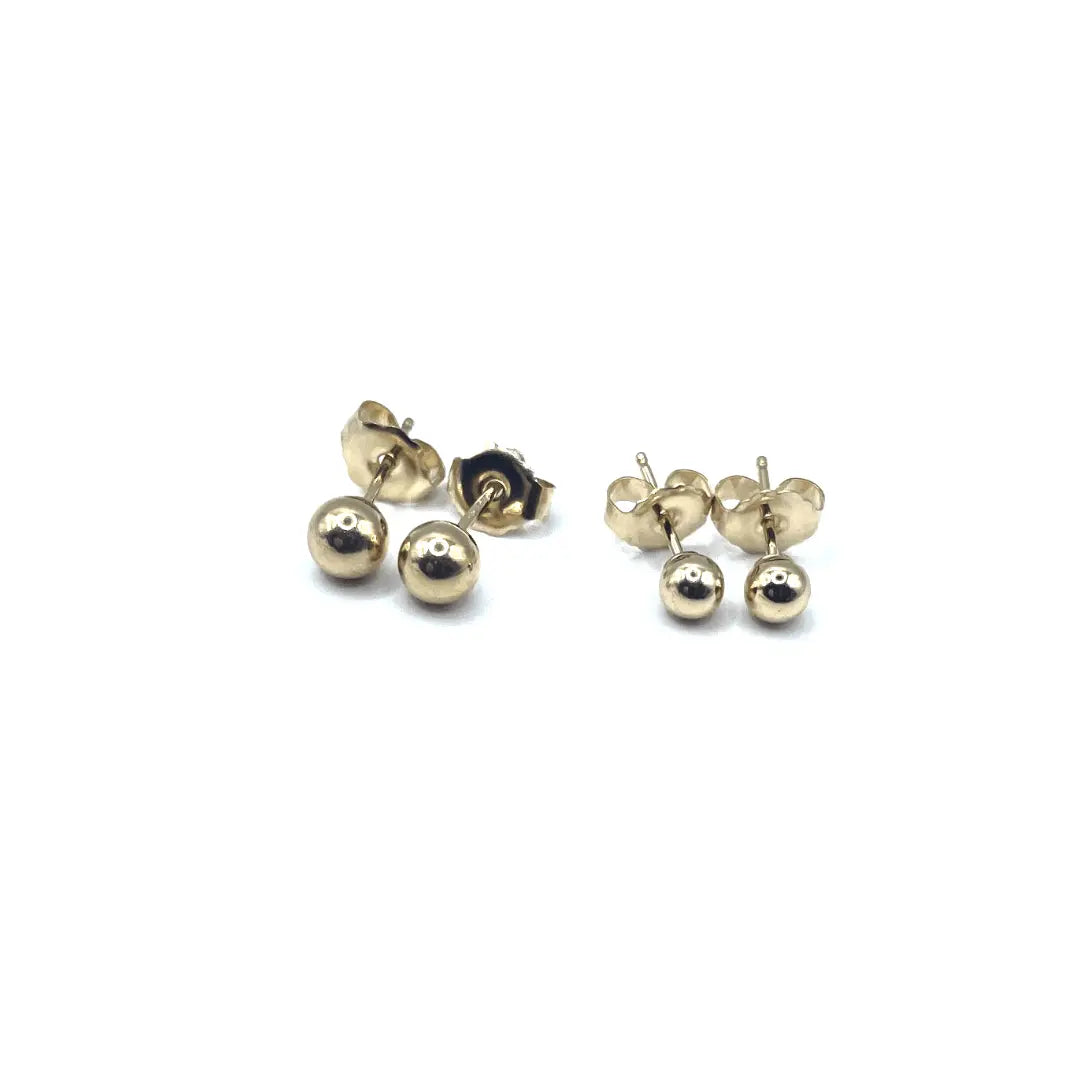 Gold-filled ball stud earring by Erin Gray, close-up of small, shiny jewelry piece with a smooth spherical design.