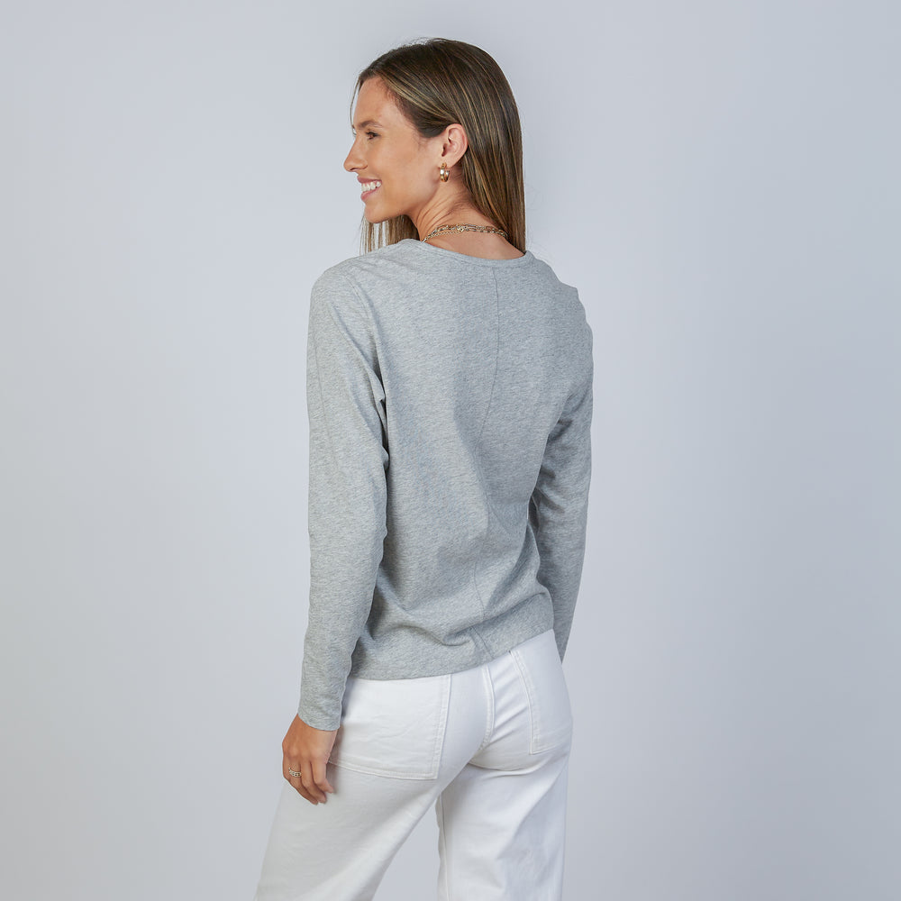 
                      
                        Woman wearing an erin gray light heathered gray classic long-sleeve shirt and white pants against a light gray background
                      
                    