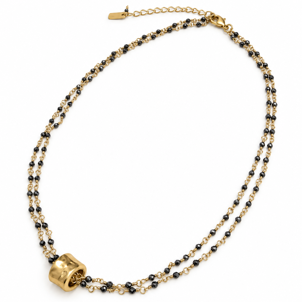 Small gold barrel pendant on double pyrite necklace from erin gray jewelry showing close-up of the necklace's pendant and chain.
