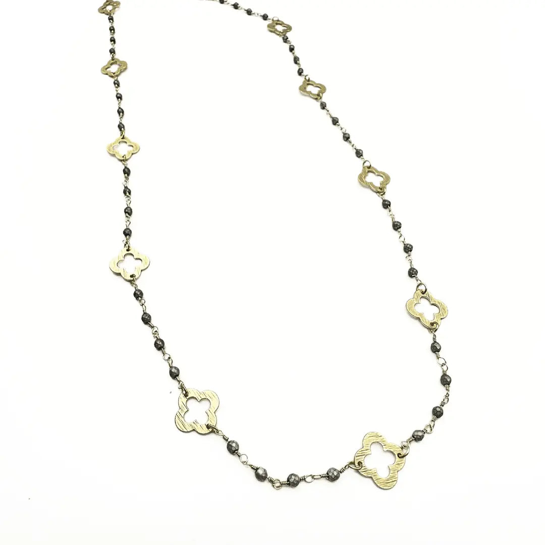 Gold clover and petite matte gray beaded long necklace by erin gray, featuring delicate beads and a subtle floral pendant.