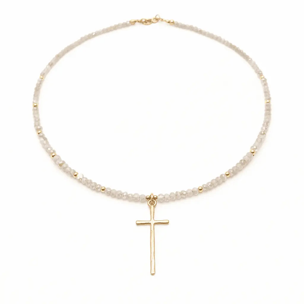 Gold prayer cross necklace in winter white, jewelry by Erin Gray, featuring a delicate cross pendant on a fine chain.