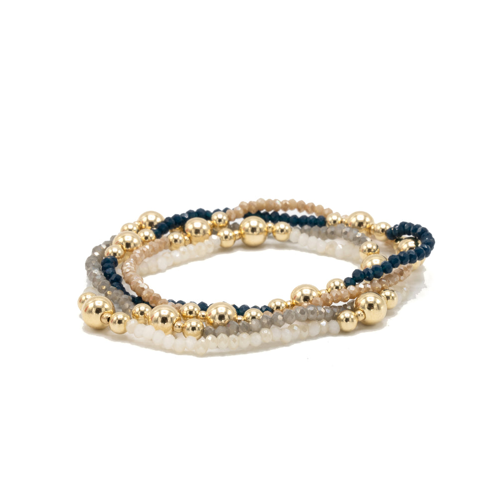 
                      
                        Set of three beaded bracelets in gold, navy, and gray on a white background
                      
                    