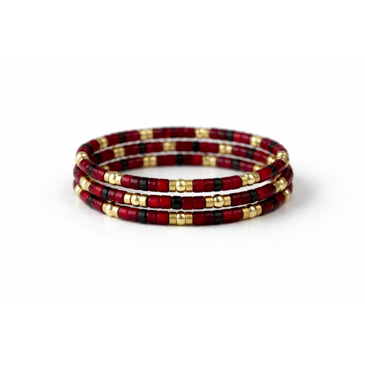 Gold-filled red stretch ring stack featuring multiple thin bands with a rich red color, designed by Erin Gray.