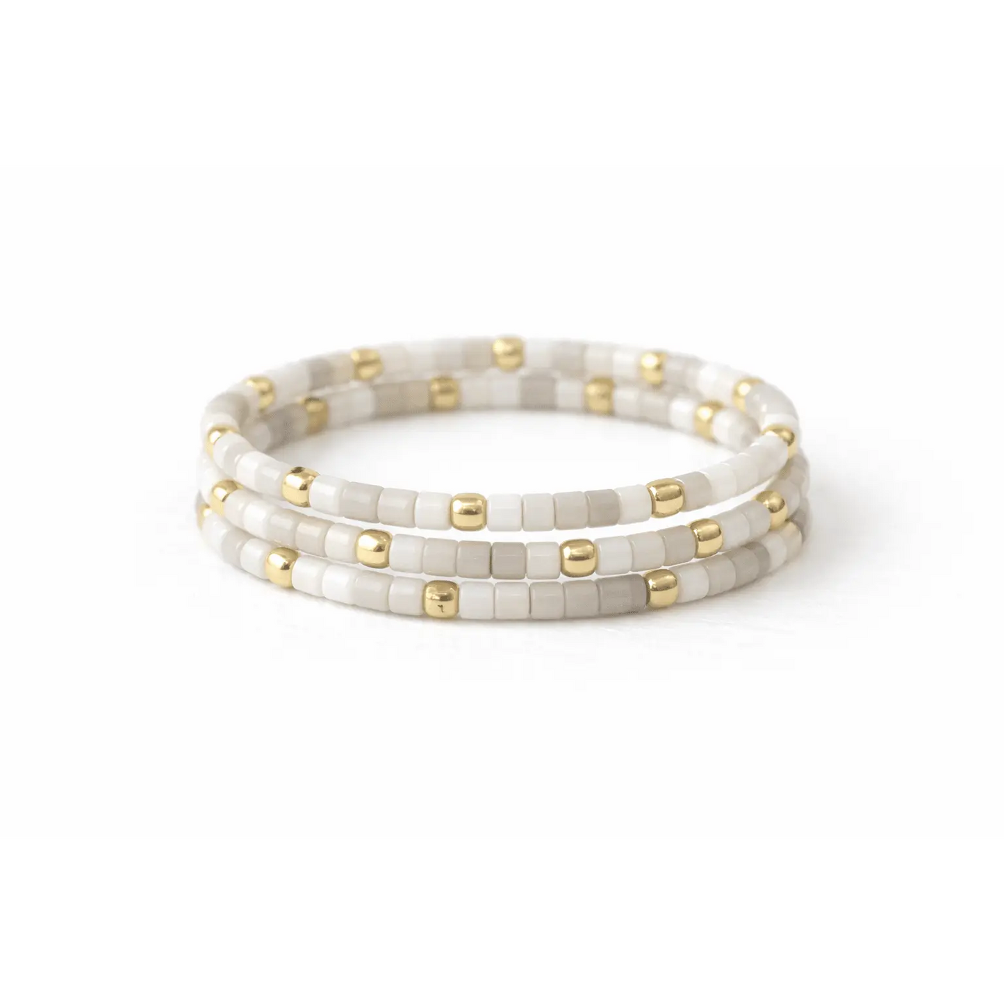 Stacked gold and white stretch rings from erin gray's Endless Summer collection, featuring 14k gold-filled jewelry with sleek, minimalist design.