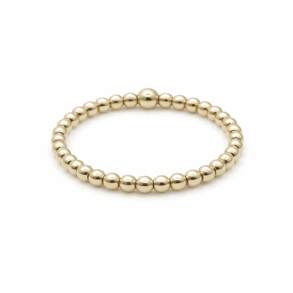 Gold filled waterproof stretch ring, 2mm wide, by erin gray, showcasing a sleek, adjustable jewelry piece in a close-up view.