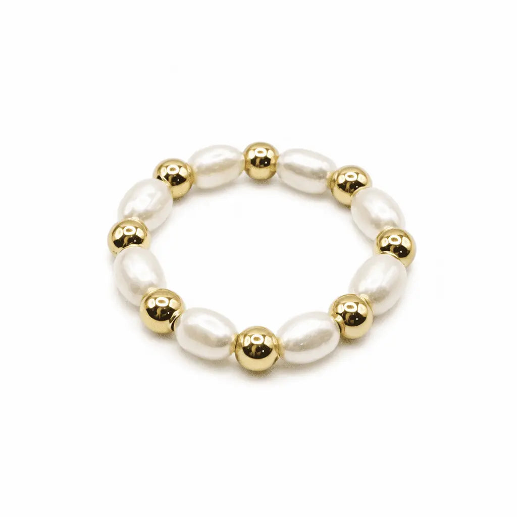 Gold-filled stretch ring with 3mm natural rice pearls, waterproof jewelry by erin gray on a plain background