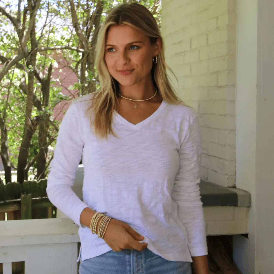 White long sleeve V-neck top made of Pima cotton slub by erin gray, shown on a model showcasing the casual, comfortable apparel style.