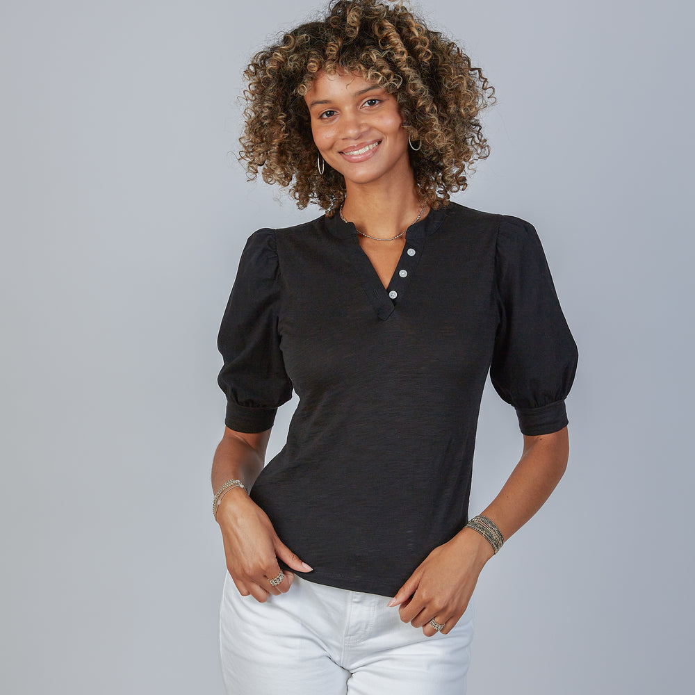 Woman wearing an erin gray black Kate blouse with puffed sleeves against a gray background