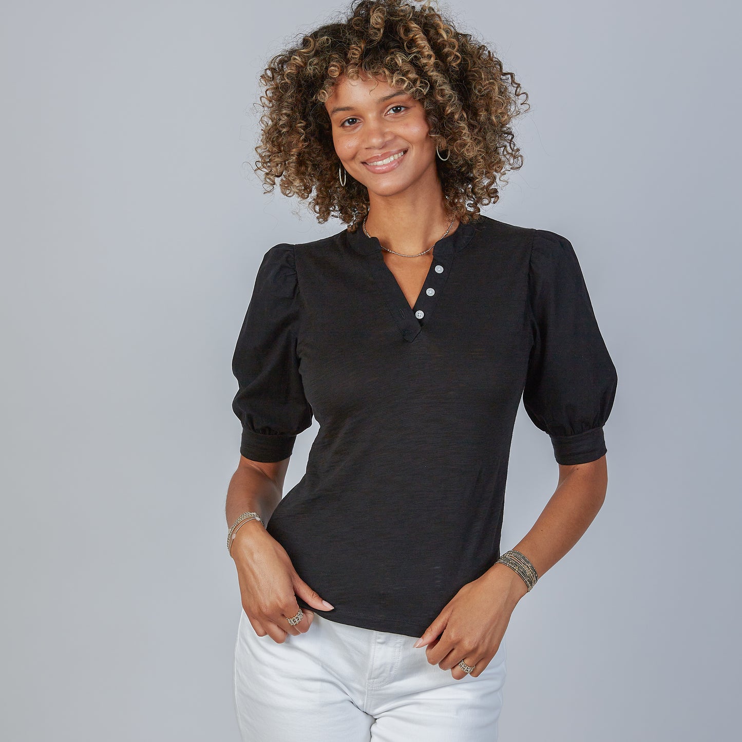 Woman wearing an erin gray black Kate blouse with puffed sleeves against a gray background