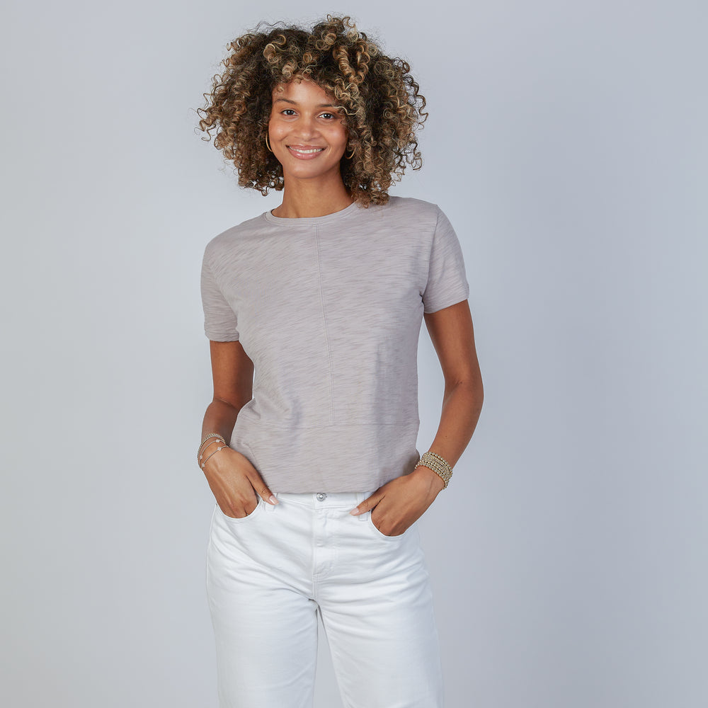 Woman wearing an erin gray dusty lilac short sleeve Celia tee against a plain background