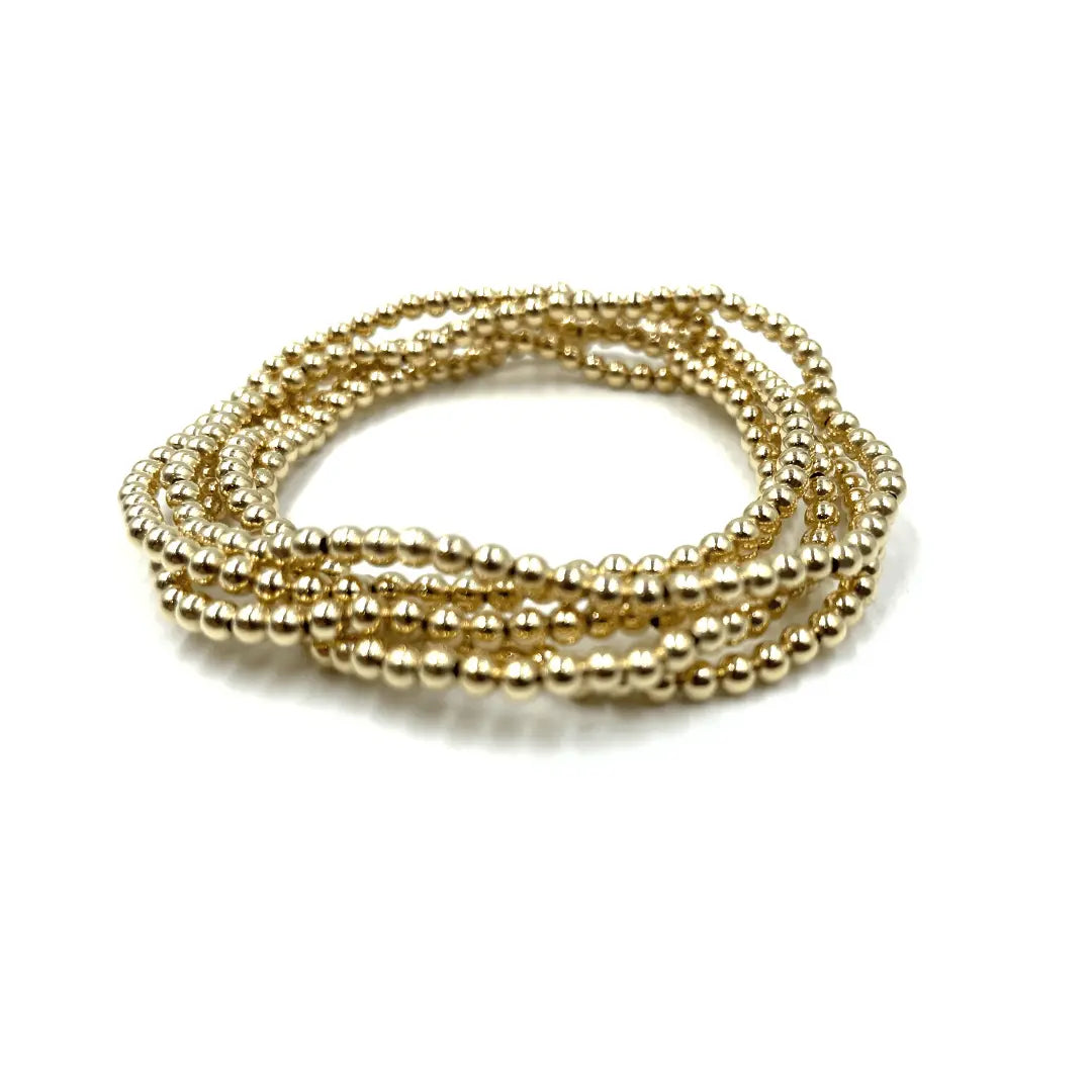 Gold-filled Karma 5-stack jewelry set featuring layered gold bracelets with a 3mm waterproof design by erin gray.