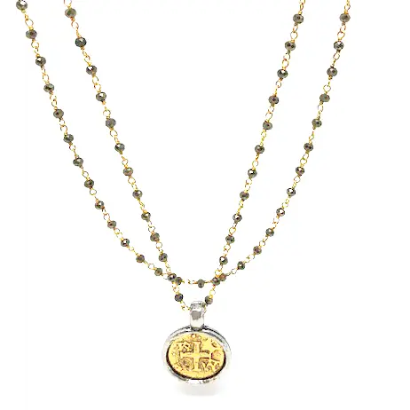 Gold coin pendant on a long pyrite necklace by Erin Gray, featuring a shiny gold coin charm and dark mineral beads.