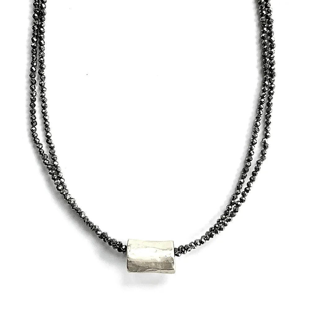 Silver barrel pendant on a double pyrite beaded necklace, elegant jewelry piece by Erin Gray with natural gemstone accents.