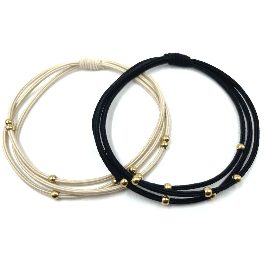 Waterproof 3mm gold water pony bracelet hair bands by erin gray in black and beige, shown in a close-up image.